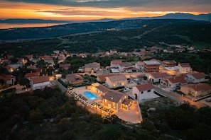 Un barrio residencial con casas, una piscina y un paisaje montañoso al fondo.