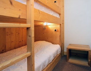 A bunk bed room with a small table and a wall-mounted light. - Apt 4/6 ppl, terrace with a very nice view (Les Deux Alpes)
