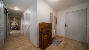 A hallway with a wooden cabinet, a patterned rug, and a door.