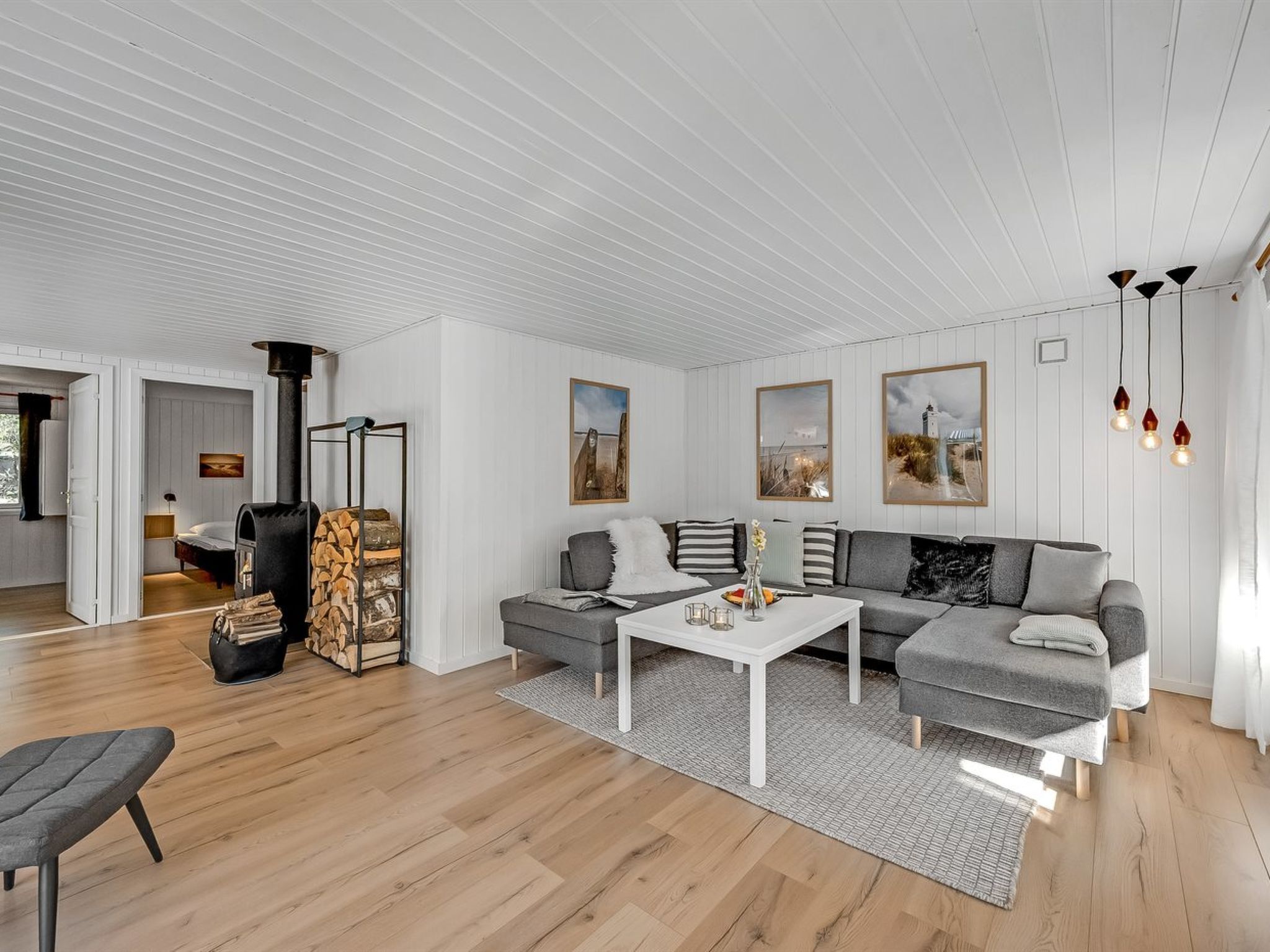 A modern living room with a sectional sofa, a coffee table, and a fireplace.
