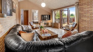 Ein modernes Wohnzimmer mit einer Ledersofa, einem Couchtisch und einem Fernseher.