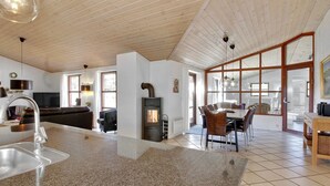 A spacious living area with a kitchen island, a fireplace, and a dining area with a large window. - "Holmved" - 1.2km from the sea by Interhome (Blåvand)