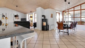 A spacious kitchen with a central island, a dining area with a table and chairs, and a large window providing natural light. - "Holmved" - 1.2km from the sea by Interhome (Blåvand)
