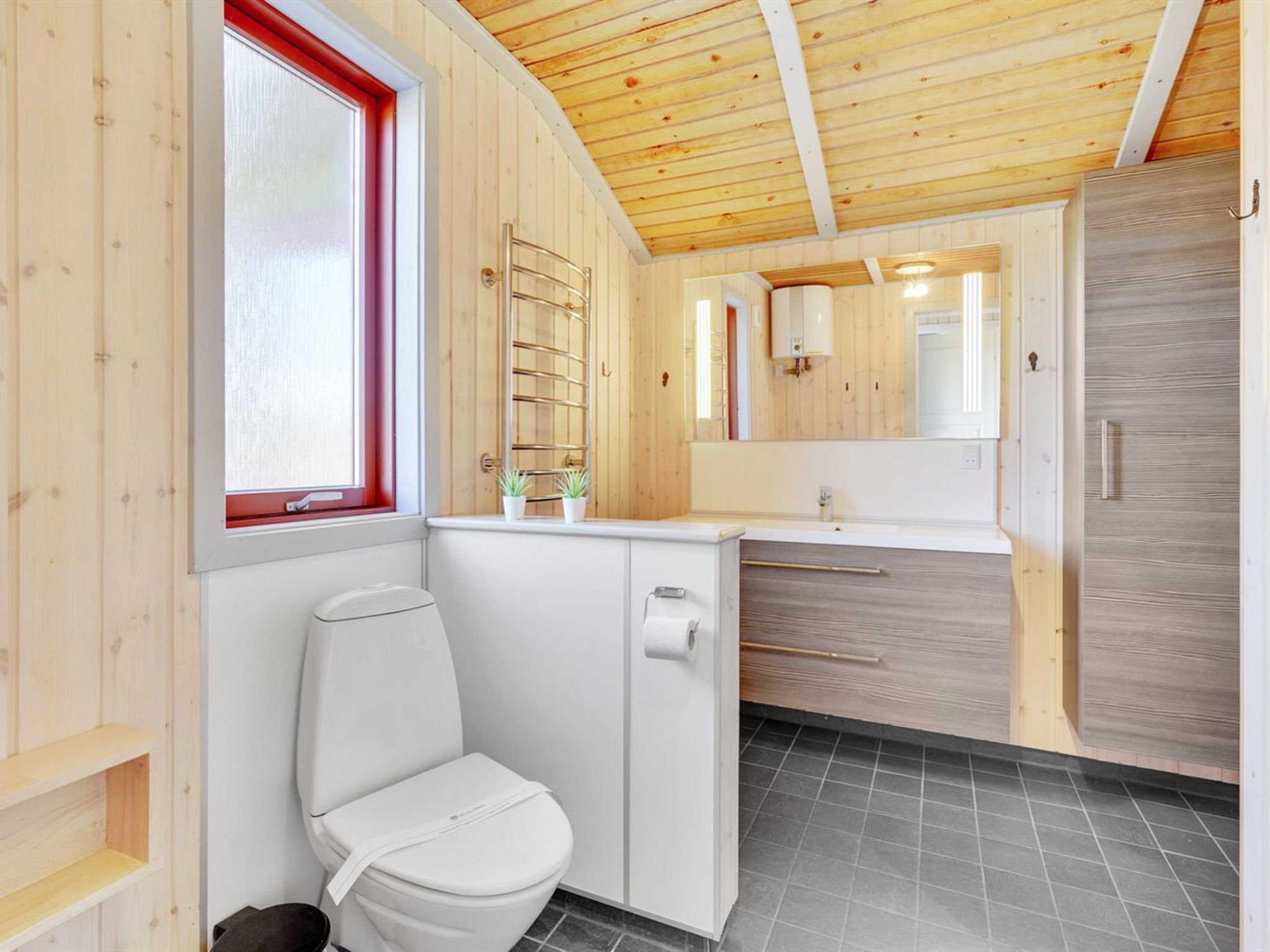 Une petite salle de bain comprenant des toilettes, un lavabo et un miroir.