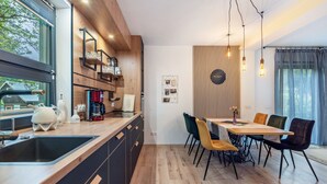 Een moderne keuken met een houten aanrecht, een spoelbak en een eethoek met een tafel en stoelen.