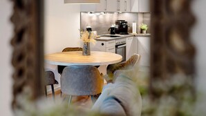 Eine moderne Küche mit Essbereich, einer Kaffeemaschine und einer Pflanze.