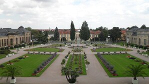 A formal garden with symmetrical pathways and a central fountain, surrounded by classical architecture. - Apartment 'Ferienwohnung Mit Terrasse, Garten' with Private Terrace, Private Garden and Wi-Fi (Gotha)