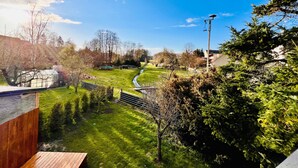 A residential area with a grassy field, a pathway, and a wooden deck.