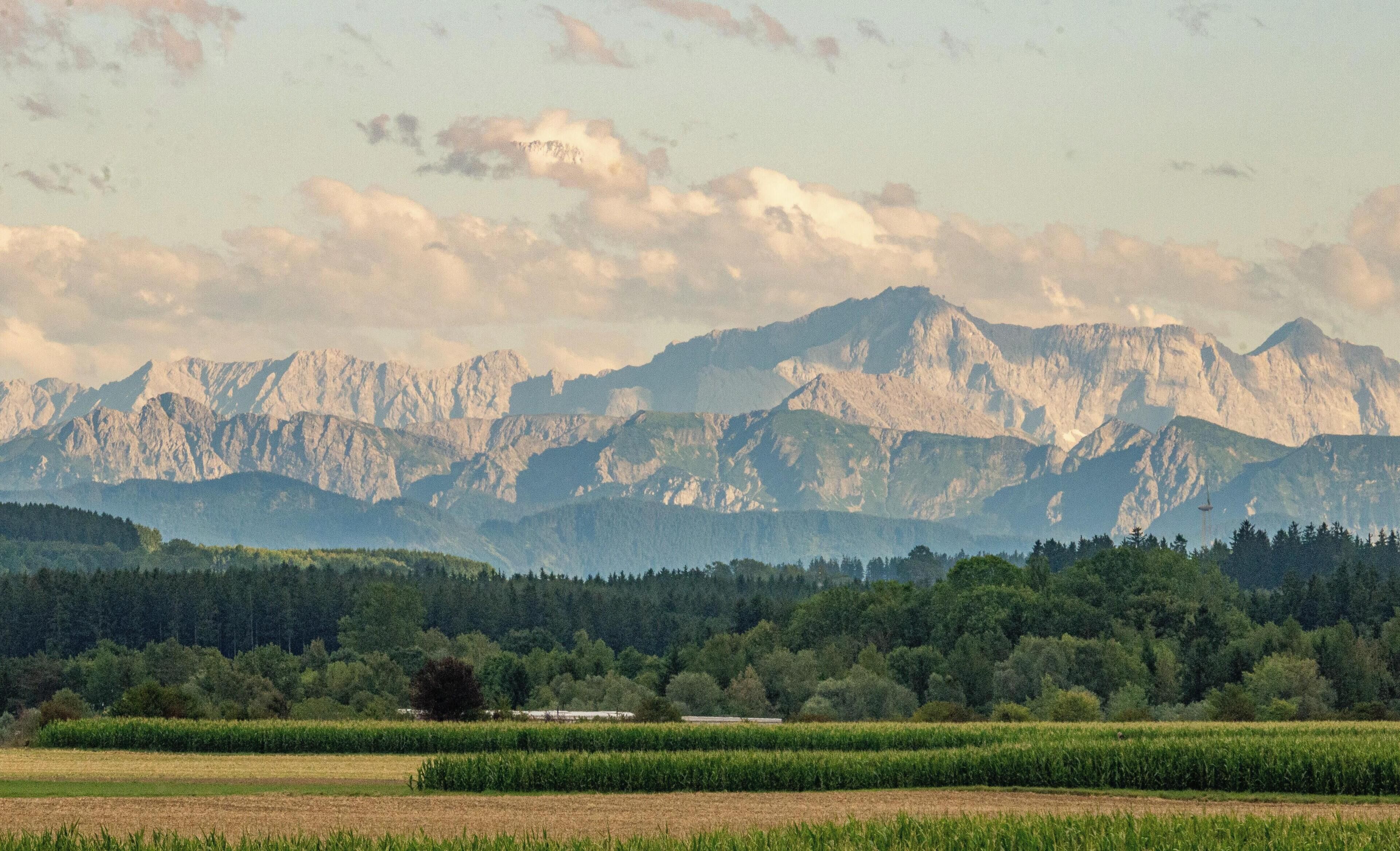 A mountainous landscape with fields and trees.