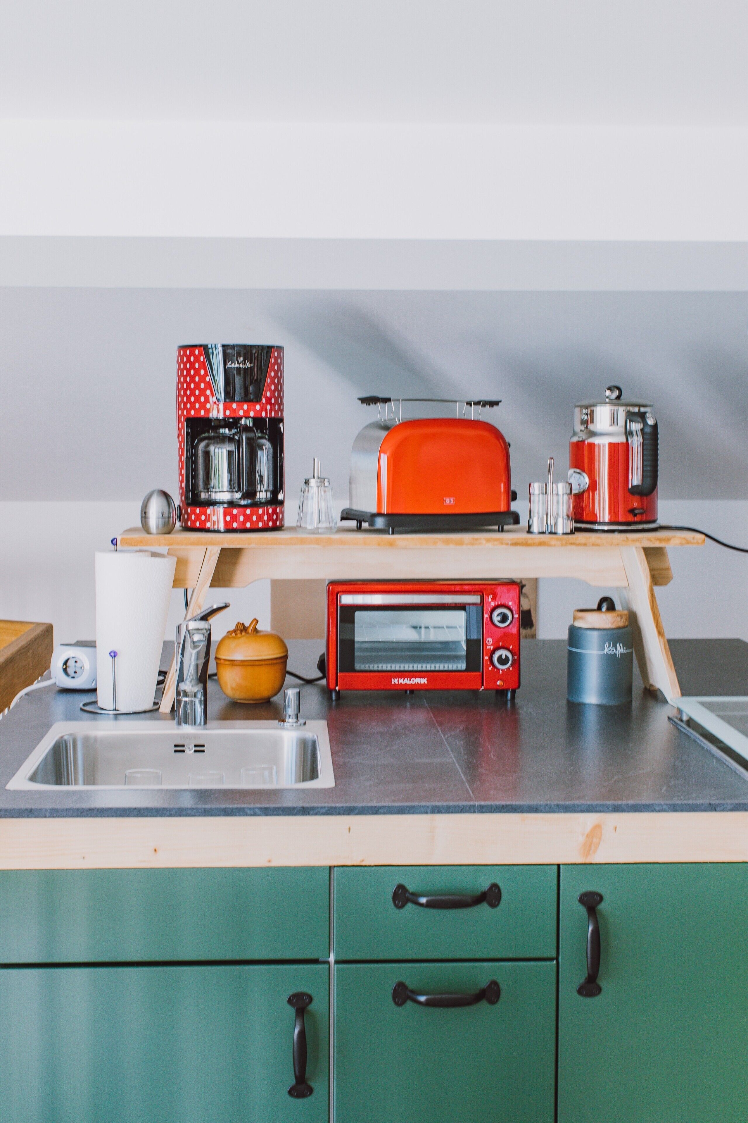 Eine Küche mit Toaster, Kaffeemaschine und Mikrowelle auf der Arbeitsfläche.
