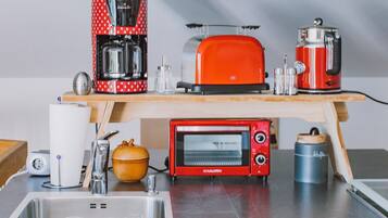 Eine Küche mit Toaster, Kaffeemaschine und Mikrowelle auf der Arbeitsfläche.