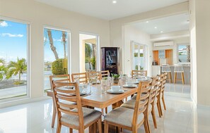 Un comedor amplio con una gran mesa dispuesta para seis personas, rodeada de sillas de madera con asientos acolchados.