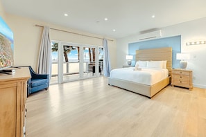 Une chambre spacieuse avec un grand lit, une table de chevet, un bureau et une chaise.