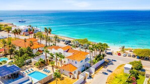 Ein Küstenresort mit Schwimmbad, Strand und klarem, blauem Meer.