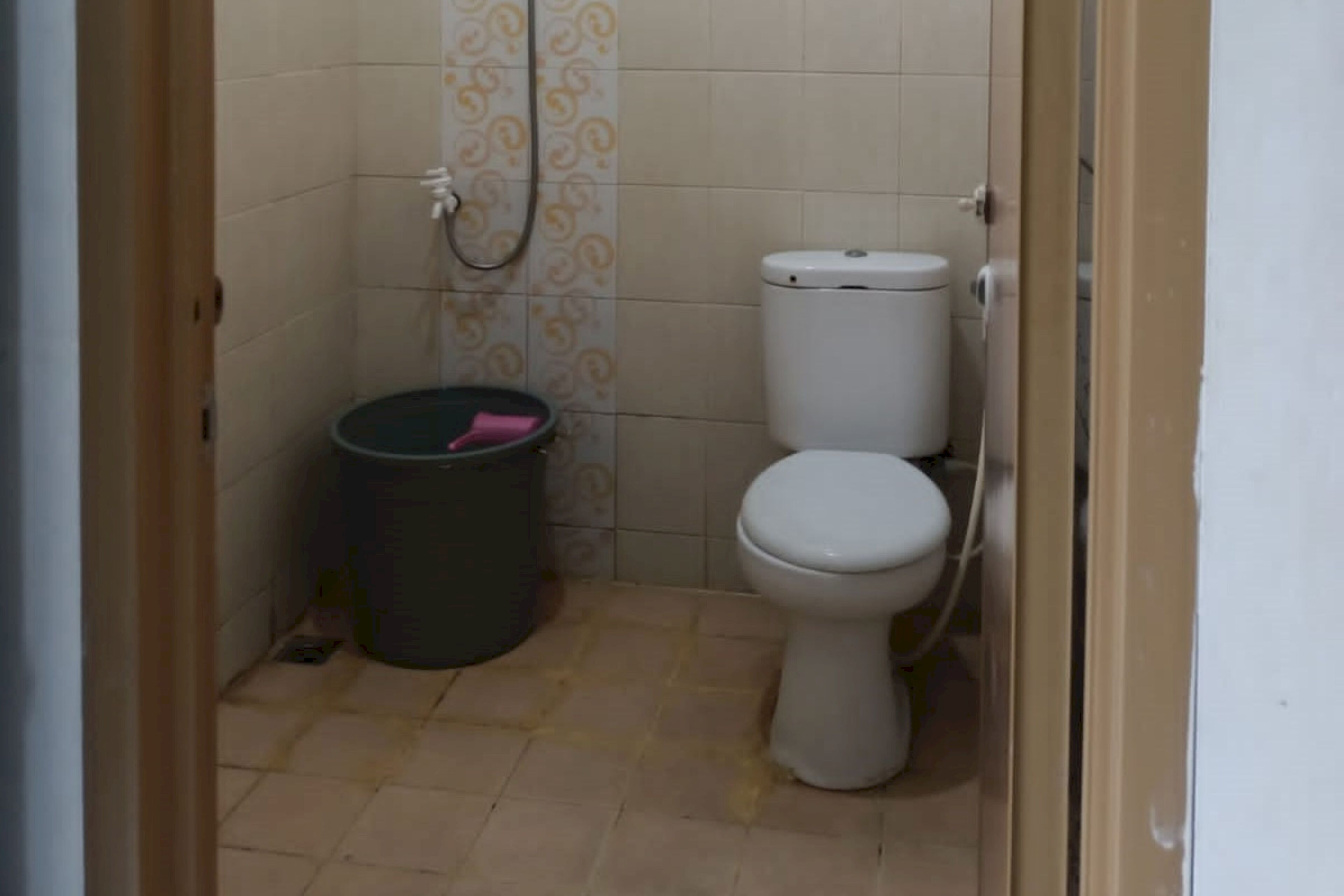 Une petite salle de bain avec des toilettes, une douche et une poubelle.