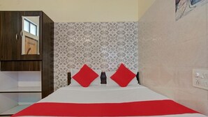 Een hotelkamer met een bed, een kledingkast en een behang met een patroon.