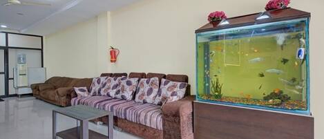A living room with a sofa, a coffee table, and a fish tank.