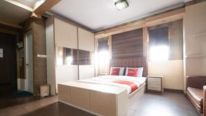 A bedroom with a large bed, bedside tables, a nightstand, and a window. - OYO 93828 Apartemen Tamansari Panoramic By Narel Room (Bandung)