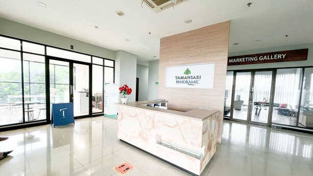 A reception area with a marble counter, a sign for Tamansari Panoramic, and a Marketing Gallery sign. - OYO 93828 Apartemen Tamansari Panoramic By Narel Room (Bandung)