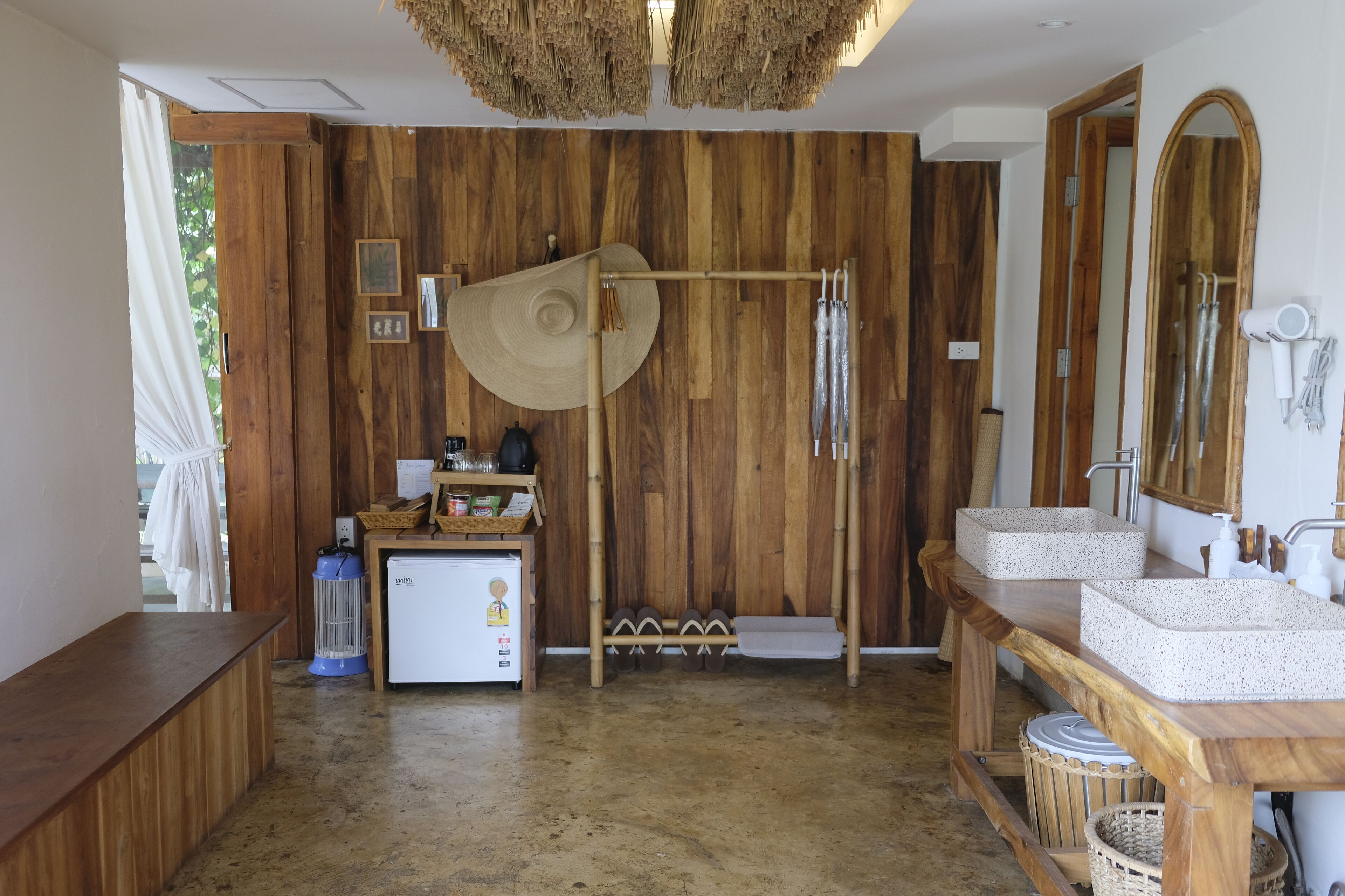 Un baño de madera con dos lavamanos, un espejo y un perchero para toallas.