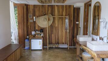 Un baño de madera con dos lavamanos, un espejo y un perchero para toallas.