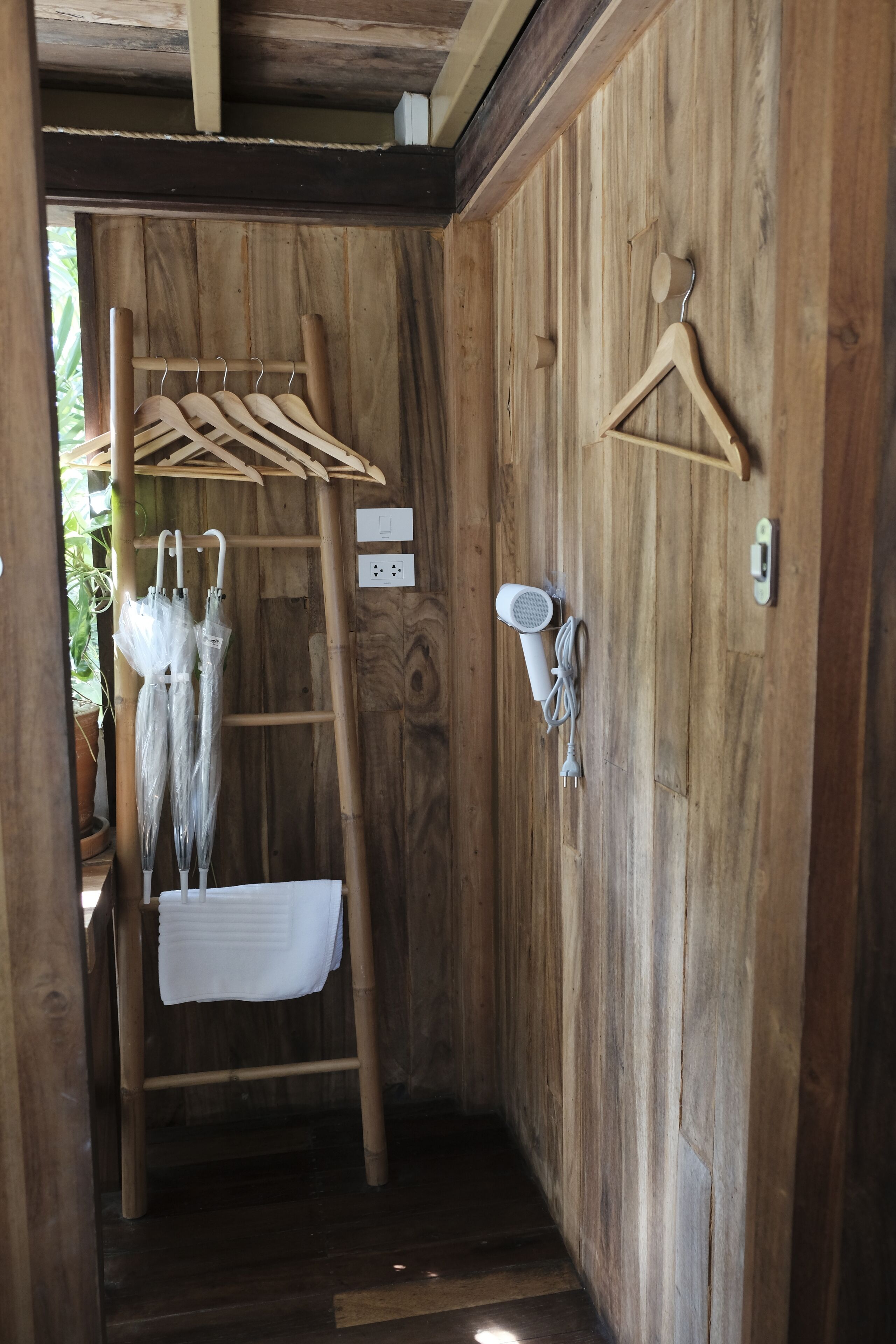 A wooden room with a wooden ladder, a white towel, and a wall-mounted light fixture.