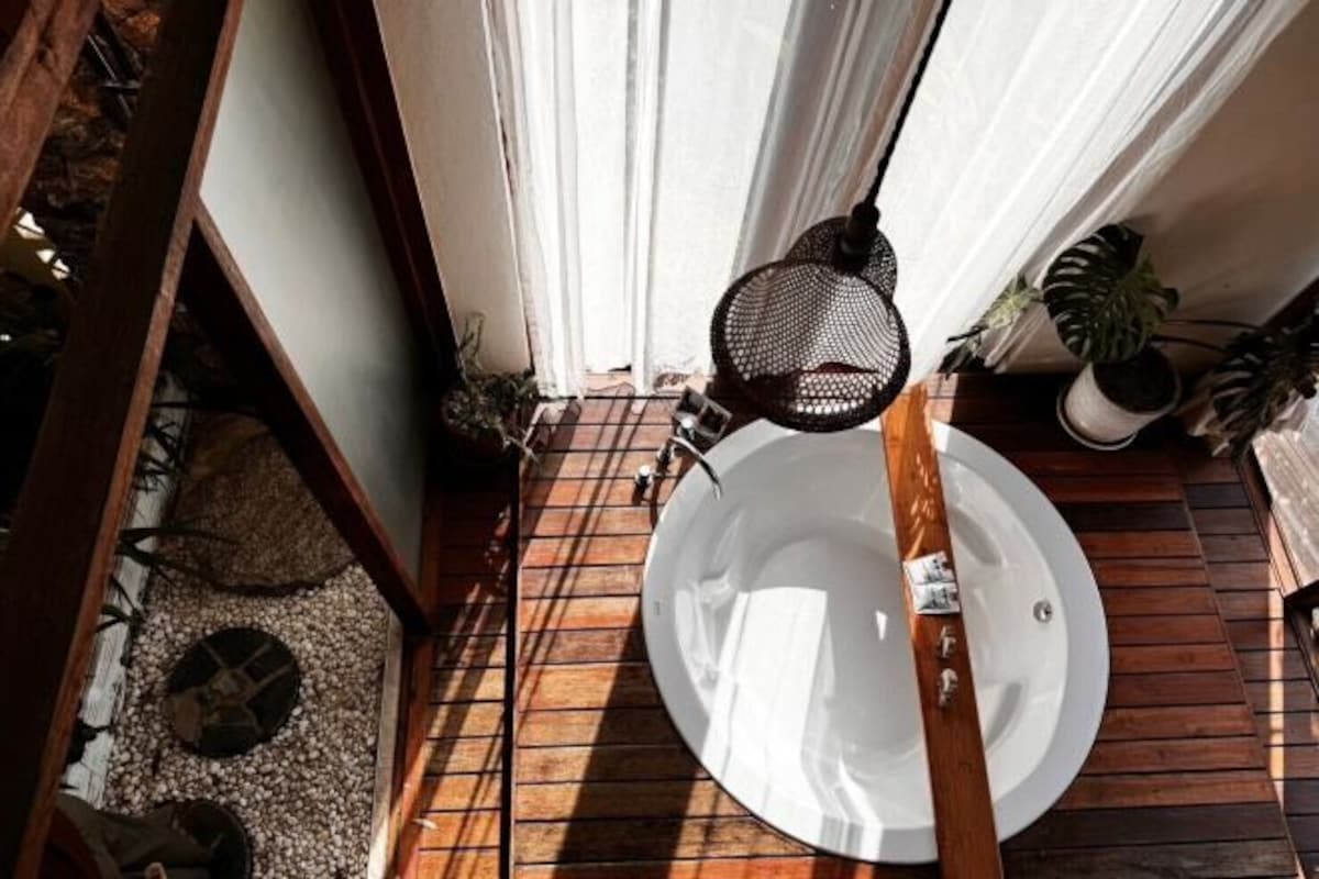 Una terraza de madera con un plato blanco, un accesorio metálico y plantas en macetas.