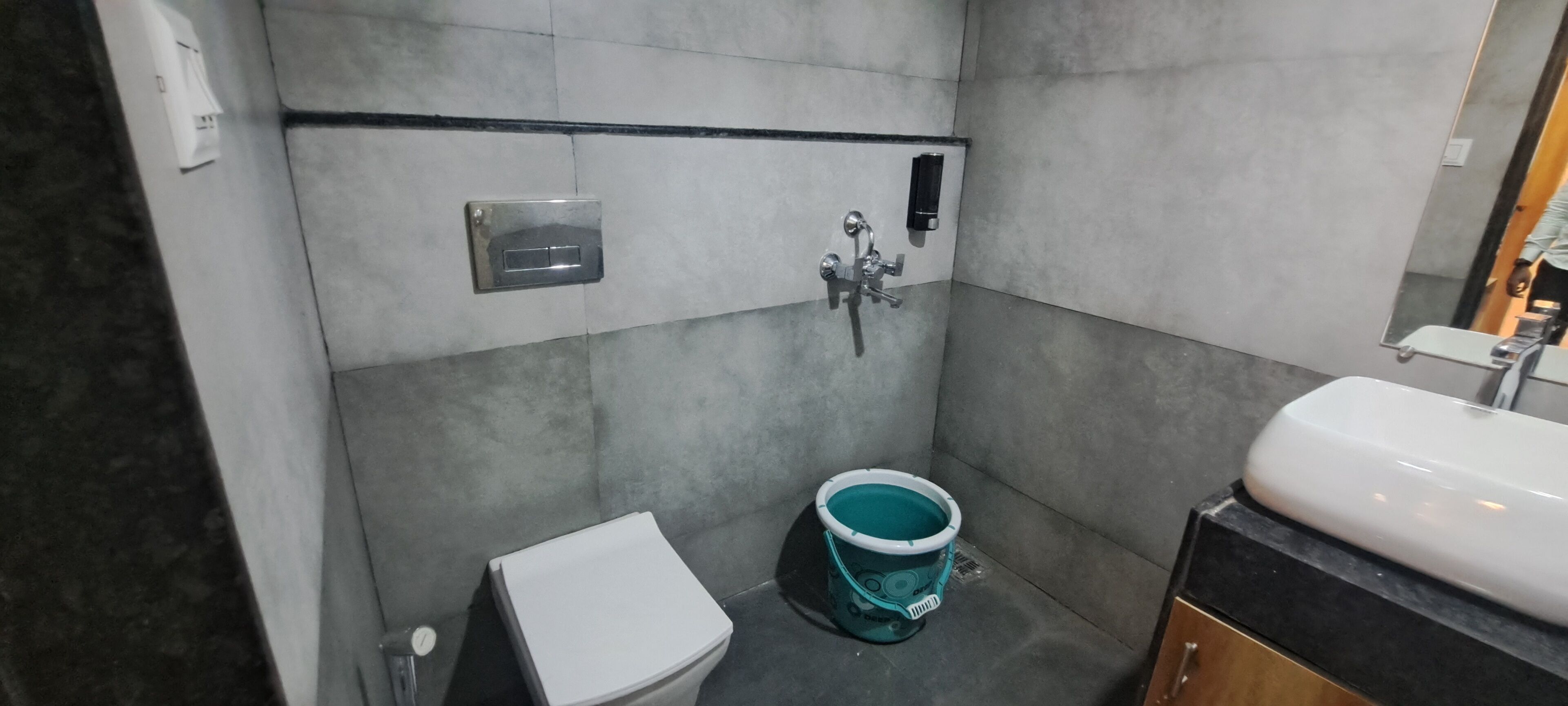 A bathroom with a toilet, a sink, and a shower with a handheld showerhead.