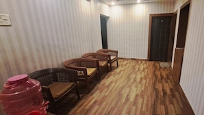 Un couloir avec un papier peint à rayures, un plancher en bois et des chaises en osier.