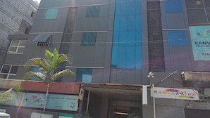 Un bâtiment moderne doté de nombreuses fenêtres et d’une enseigne indiquant « KANVASKIDZ, école maternelle et centre de garde d’enfants » sur sa façade.