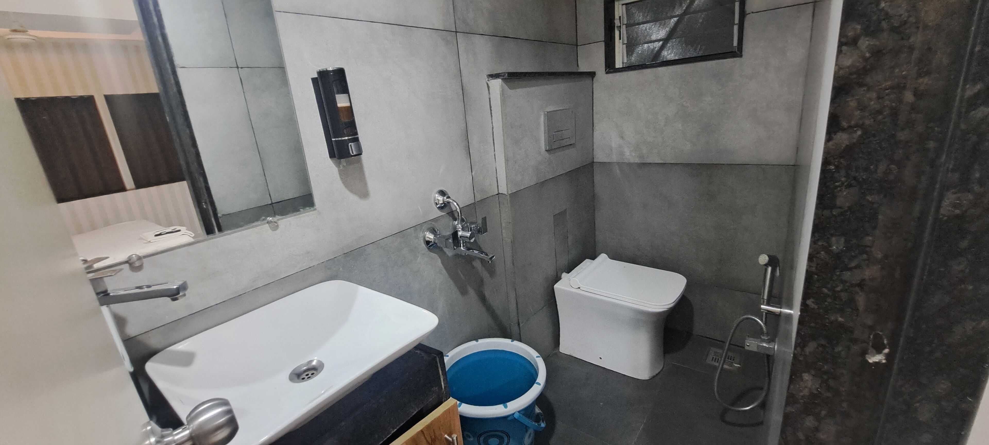 A modern bathroom with a white sink, a toilet, and a shower.
