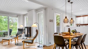 Un intérieur moderne comprenant un coin repas, des chaises, une table et une cheminée.