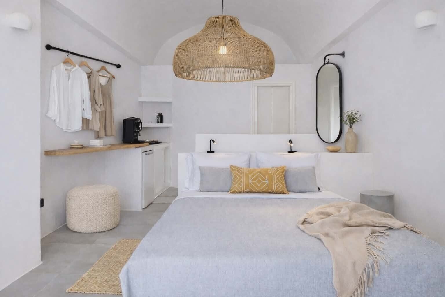 Un dormitorio moderno con cama, mesita de noche, perchero y una gran lámpara colgante de fibras.