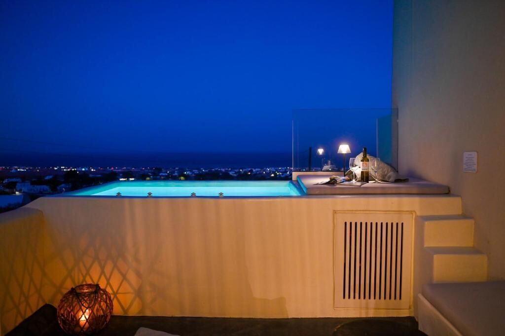 Ein Poolbereich mit Blick auf die beleuchtete Stadt bei Nacht.