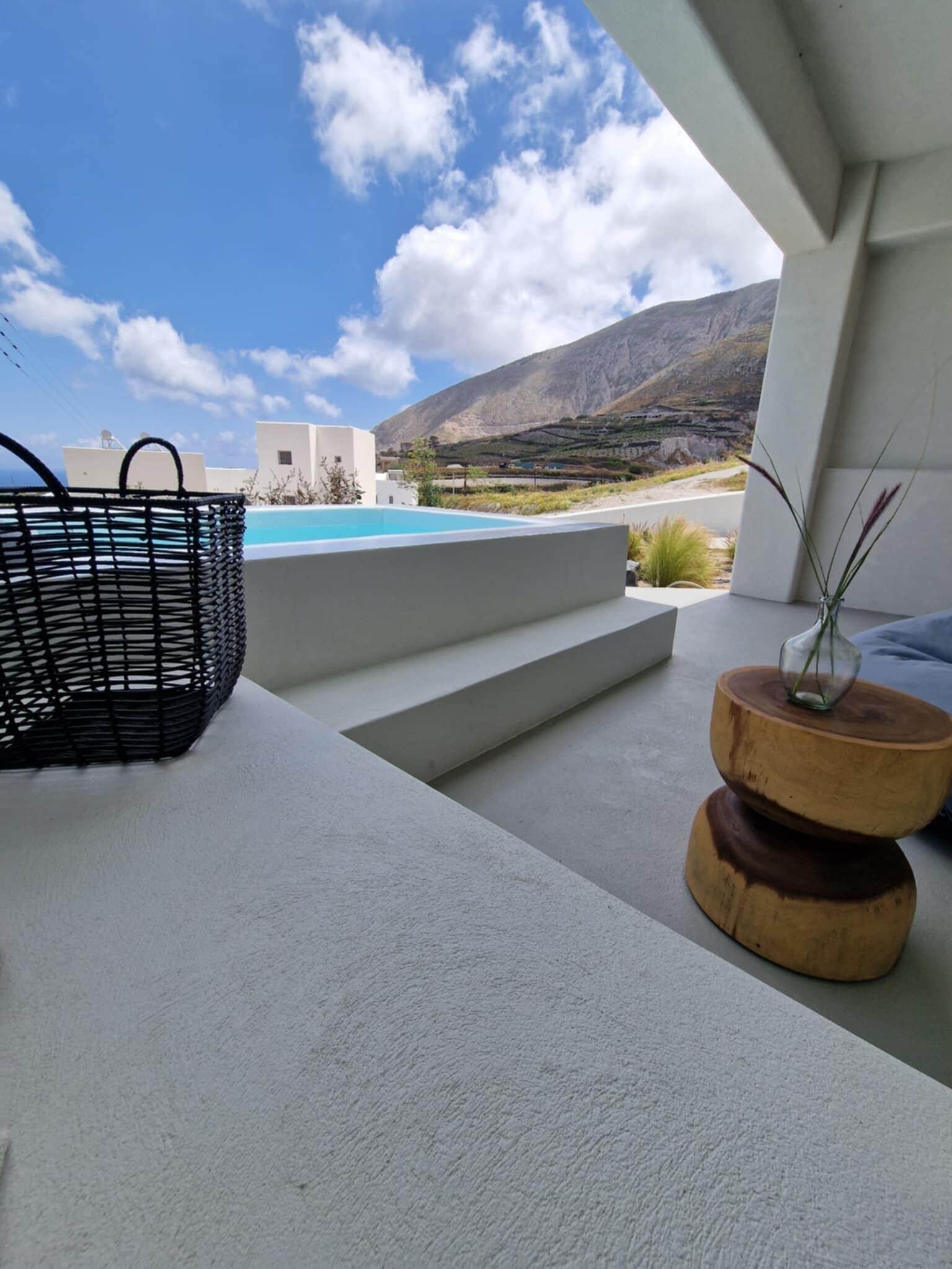 A modern outdoor seating area with a view of a pool and mountains.