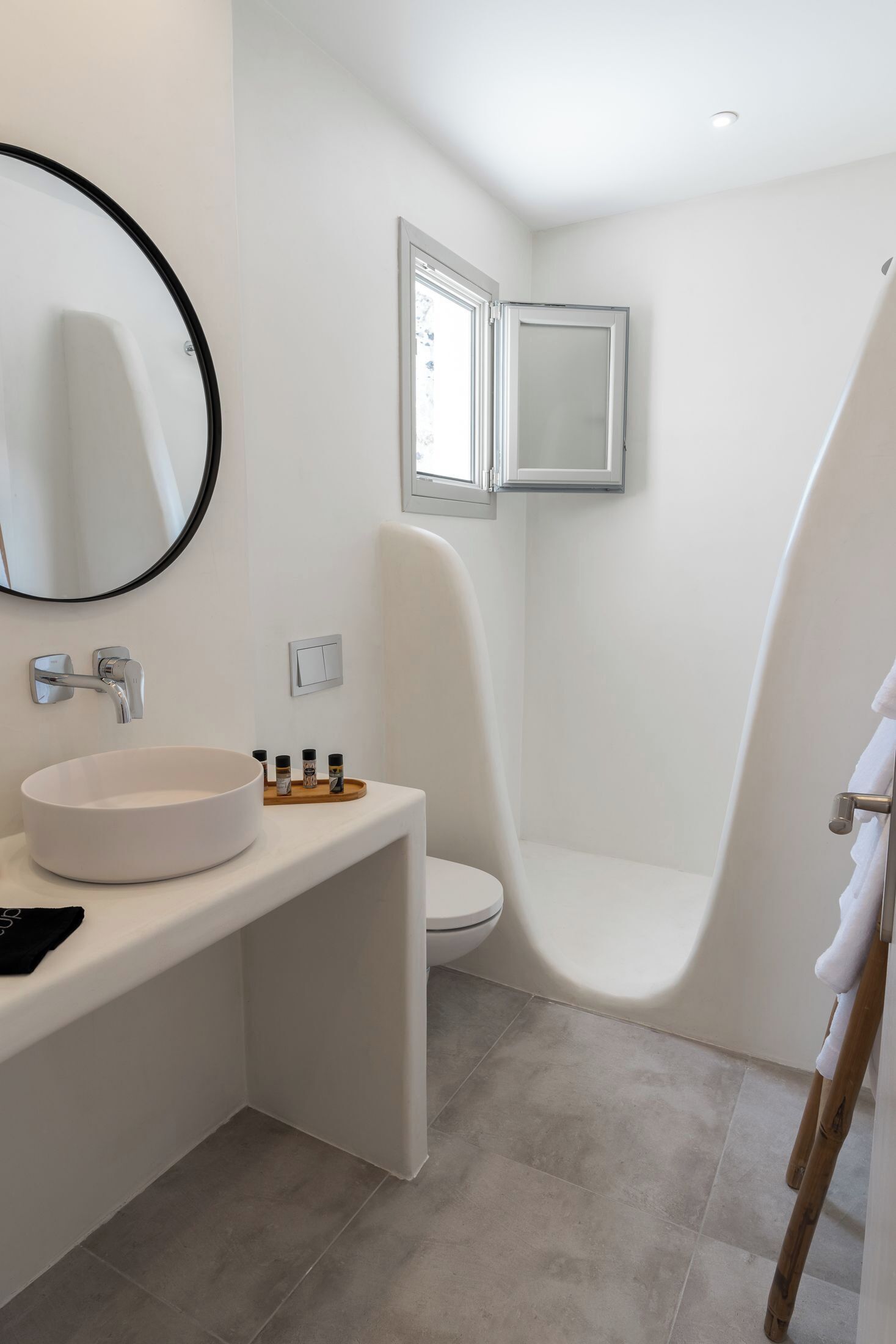 A modern bathroom with a white sink, mirror, and toilet.