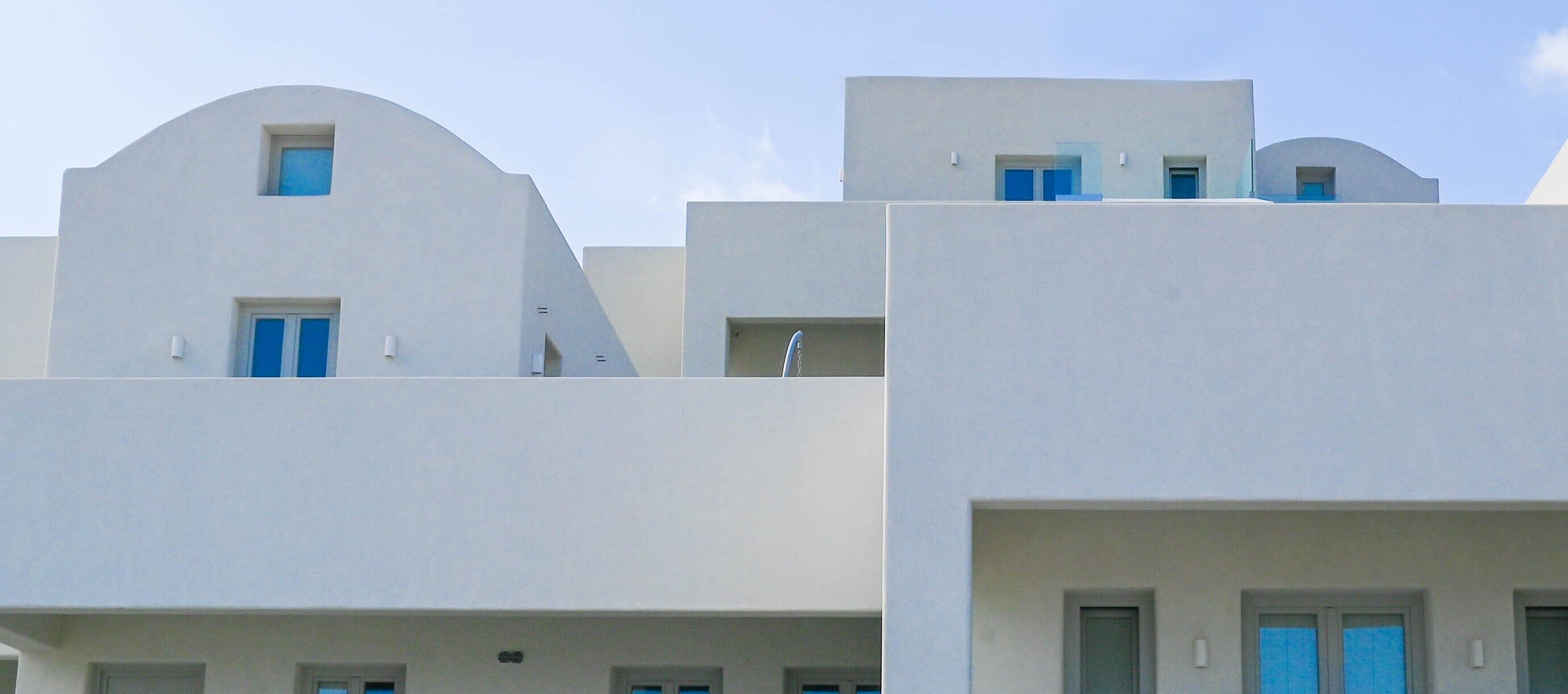 Eine Reihe weißer Gebäude mit blauen Türen und Fenstern, die einen modernen Baustil zeigen.