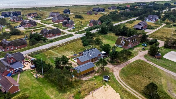 An aerial view of a coastal village with traditional houses, a sandy area, and a road leading to the beach. - "Dirtje" - 200m from the sea by Interhome (Blåvand)
