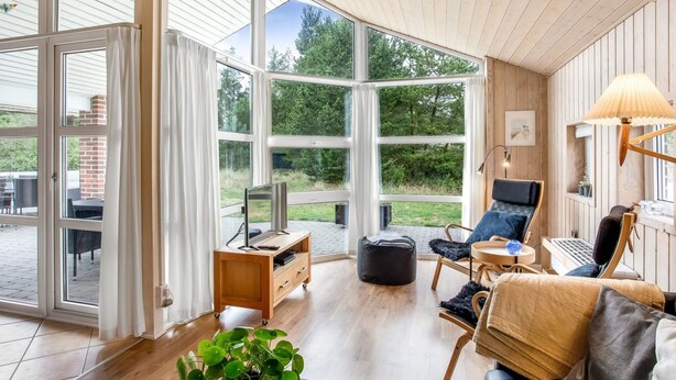 A spacious room with large windows, a wooden ceiling, and a cozy seating area with a sofa, chairs, and a table. - "Ronna" - 2.2km from the sea by Interhome (Blåvand)