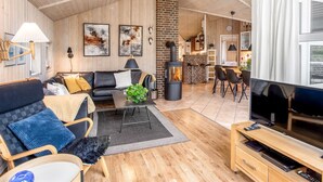 A modern living room with a fireplace, a sofa, a coffee table, and a TV. - "Ronna" - 2.2km from the sea by Interhome (Blåvand)