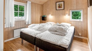 A double bed with white bedding in a room with wooden walls and floors. - "Ronna" - 2.2km from the sea by Interhome (Blåvand)