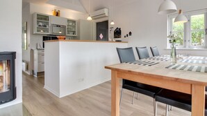 A modern kitchen with white cabinets, a central island, and pendant lighting. - "Moa" - 800m from the sea by Interhome (Blåvand)