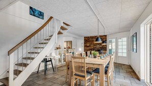 A spacious kitchen with a dining area, a staircase, and a kitchen island.