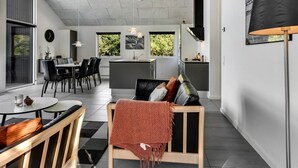 Un interior moderno con comedor, cocina y zona de estar.
