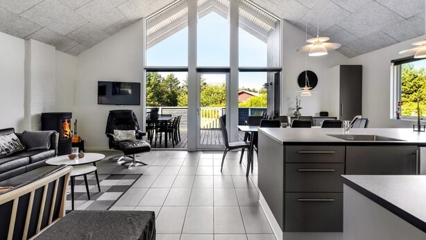 Una cocina moderna con una isla grande, un comedor con vistas y una zona de estar acogedora con chimenea.