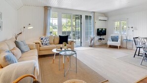 A spacious living room with a beige sofa, a small coffee table, and a TV on a stand. - "Sine" - 500m from the sea by Interhome (Blåvand)