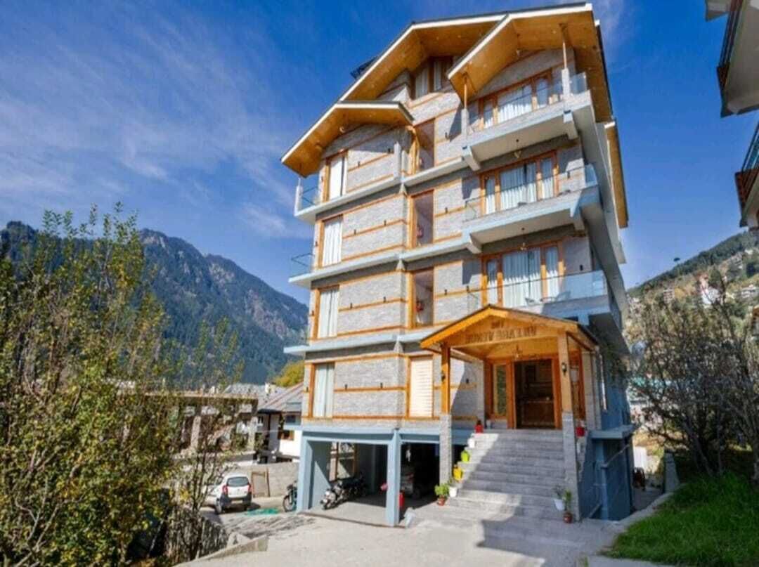 Een meerlaags hotel met een klassieke architectuur, met balkons en een centrale ingang.
