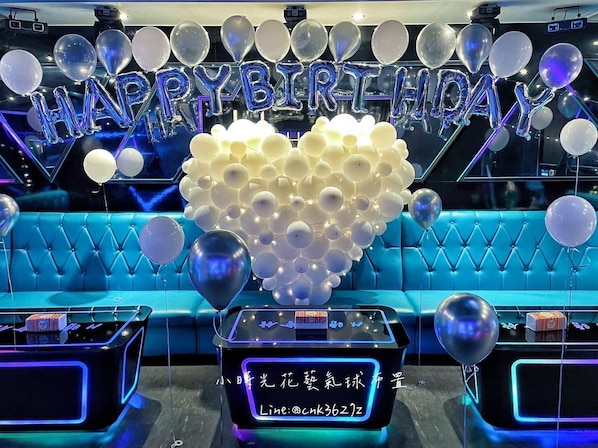 A blue sofa with a heart-shaped balloon decoration and a neon sign with a phone number. - H-house (Dongshan)