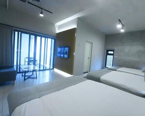 A hotel room with a large bed, a desk, and a chair. There is a TV mounted on the wall and a sliding door leading to a balcony. - H-house (Dongshan)