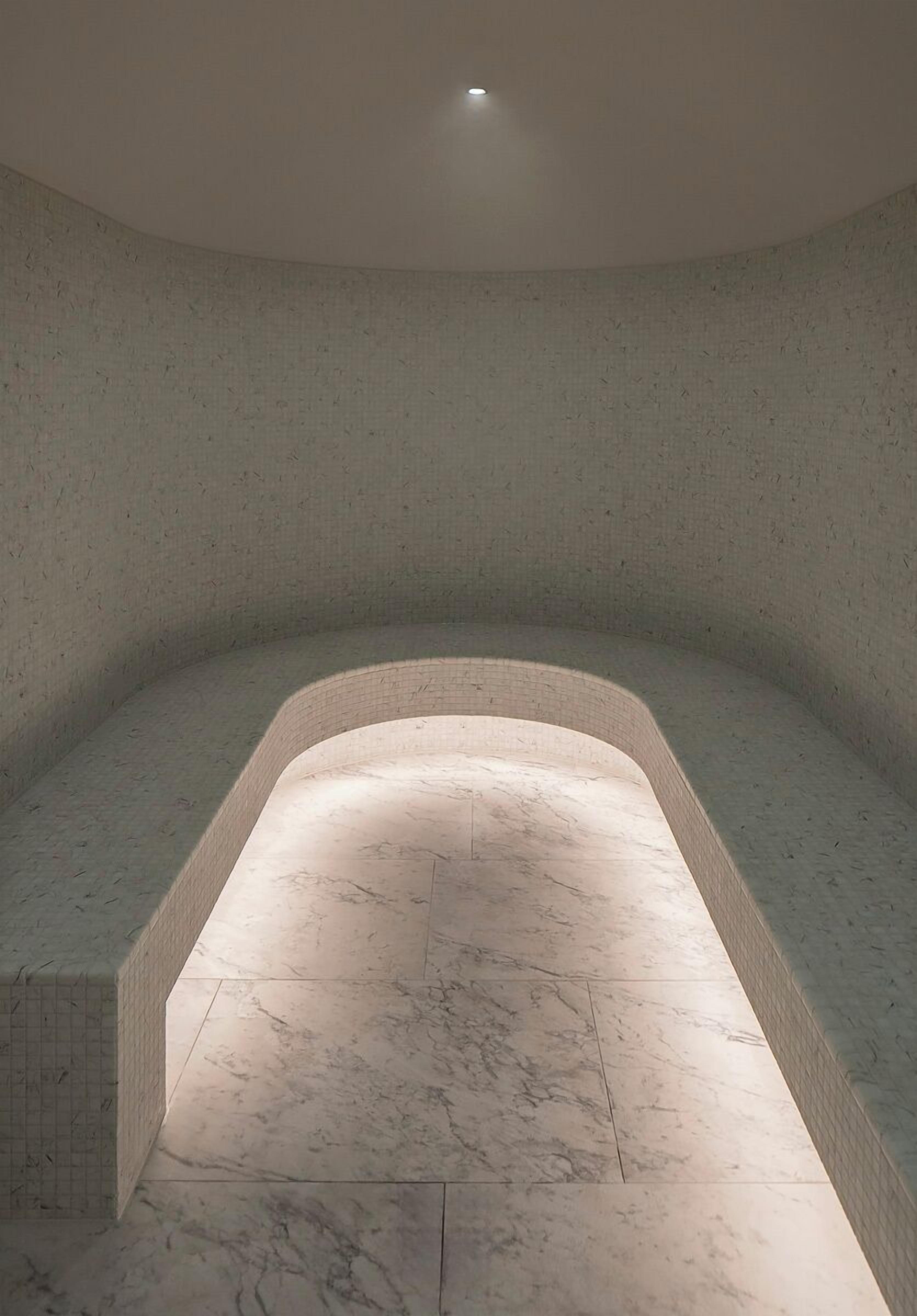 A spa room with a curved seating area and a marble floor.